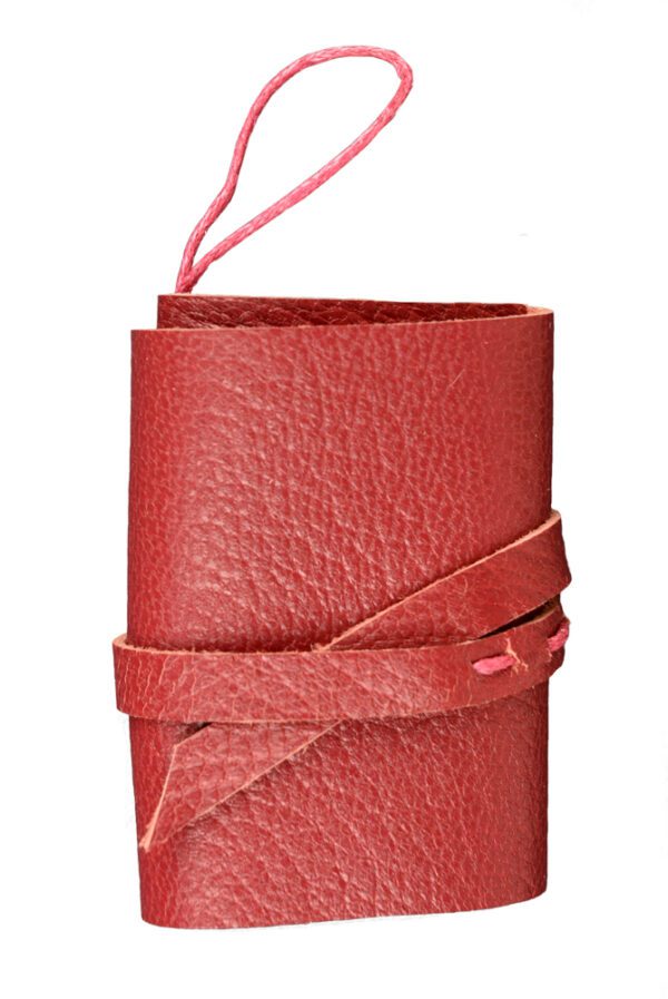 A red leather wrap around pouch with a pink string.