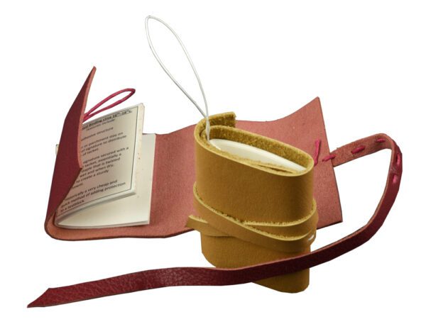 A book with a strap and a cup on it