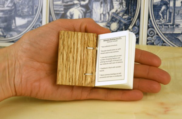 A person holding an open book with the pages folded in.