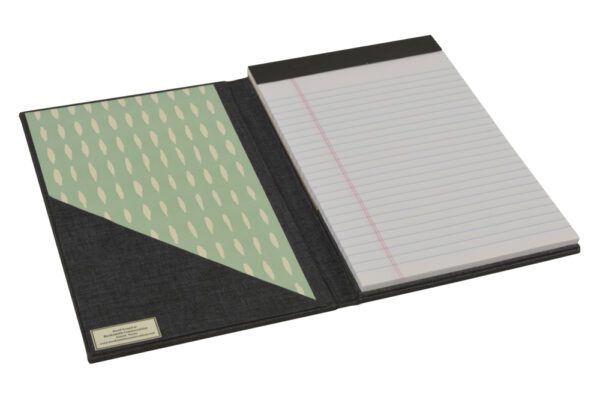 A black leather notebook with a green and white paper.