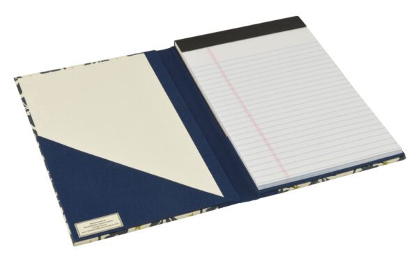 A blue and white notebook with a notepad on top of it.