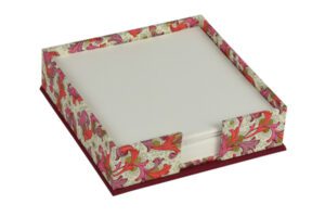 A red and white paper holder with flowers on it.