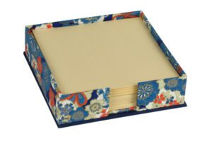 A blue and red floral paper holder with a beige pad.