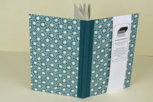 Teal notebook with white starburst pattern.