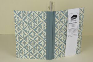 Here's an alt text suggestion for the image: Blue patterned hardback notebook.