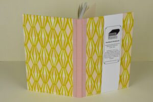 Yellow and pink patterned hardback notebook.