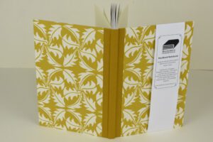 Mustard yellow hardback notebook with leaf pattern.