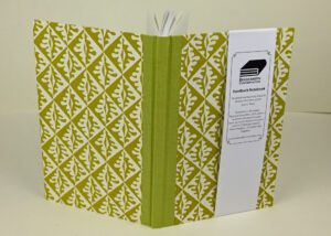 Mustard-colored hardback notebook with leaf design.